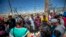 FILE— In this photo taken on Tuesday, May 9, 2023, migrants pray before turning themselves in to immigration authorities in downtown El Paso, Texas. As confusion explodes in El Paso, faith leaders continue to provide shelter, legal advice and prayer.