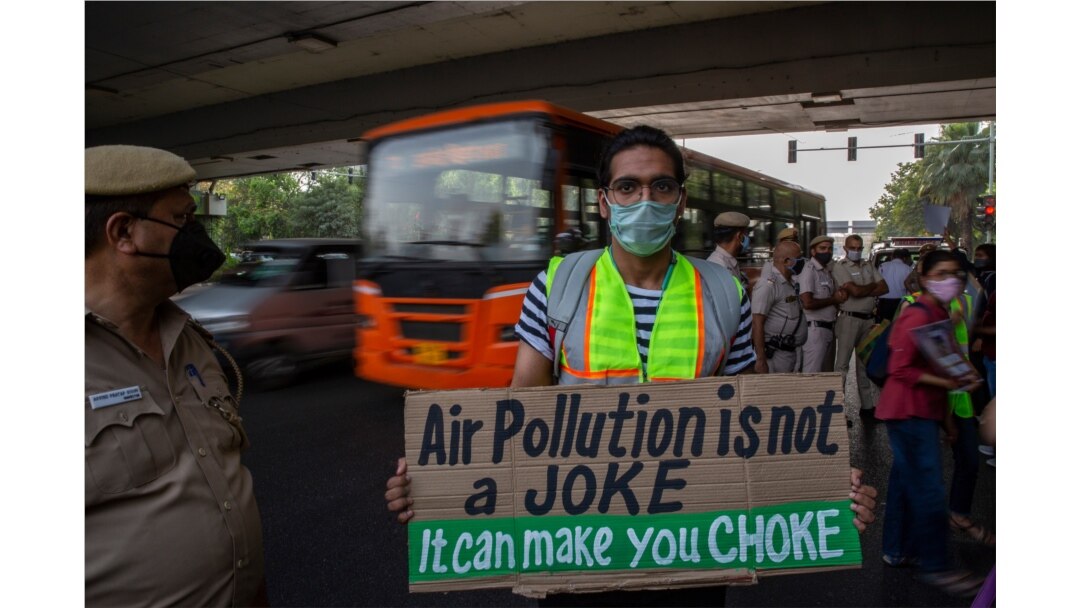 FILE - A student activist holds a placard as he participates in a protest march against climate change in New Delhi, India, March 19, 2021.