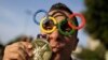 A man poses for a picture wearing Olympic rings glasses and kissing a medal before entering the Maracana Stadium ahead of the opening ceremony for the 2016 Summer Olympics in Rio de Janeiro, Brazil, Aug. 5, 2016.