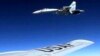 FILE - In this image released by the U.S. Air Force, a U.S. RC-135U flying in international airspace over the Baltic Sea, is intercepted by a Russian SU-27 Flanker, June 19, 2017. A Russian jet made an "unsafe" intercept of an American reconnaissance plane flying in international airspace over the Black Sea, Nov. 5, 2018, Pentagon officials said.