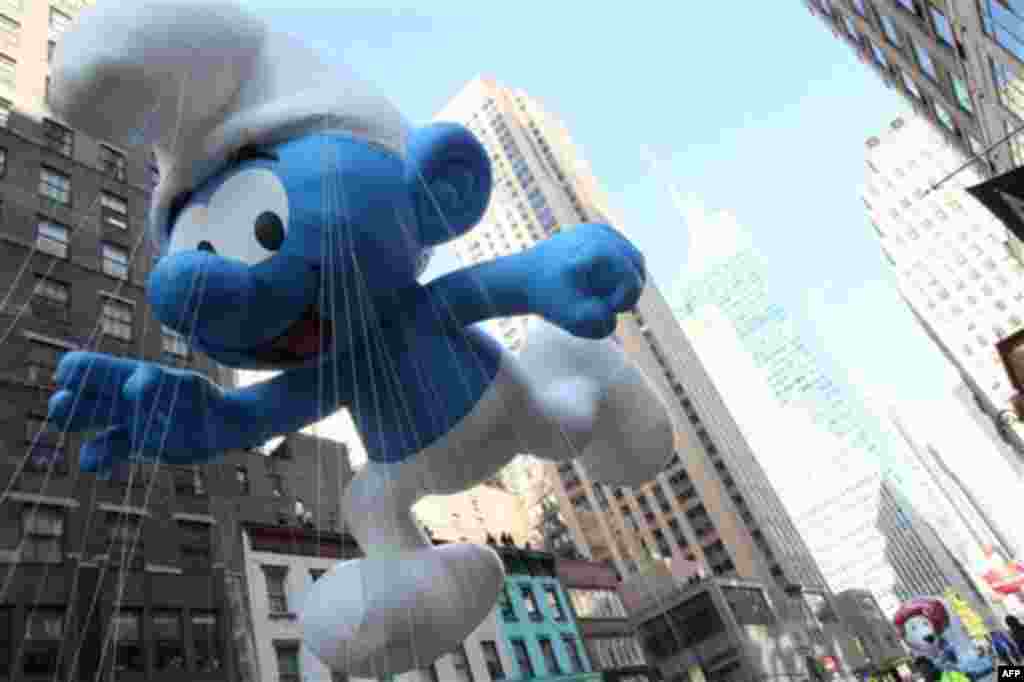 The Smurf balloon makes its way down New York's Sixth Avenue as it takes part in the 85th Annual Macy's Thanksgiving Day Parade Thursday Nov. 24, 2011. (AP Photo/Tina Fineberg)