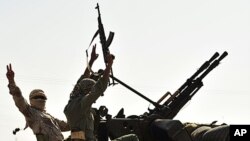 Anti-Gadhafi fighters with weapons move to the front line, 90 km east of Sirte, from Om El Qandil, 90 km west of Ras Lanuf September 6, 2011.