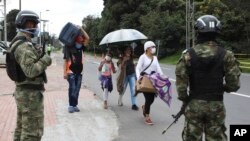 Bajo la vigilancia de soldados colombianos, migrantes venezolanos parten a pie a la frontera con Venezuela luego de un cierre para prevenir la propagación del coronavirus, en Bogotá, Colombia. Abril 6, 2020. Foto: AP.