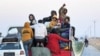 FILE - Syrian Kurds ride in the back of a vehicle to flee areas on the outskirts of the northern city of Aleppo that were formerly controlled by the Kurdish-led Syrian Democratic Forces (SDF), after they were seized by Islamist-led rebels on Dec. 2, 2024. 