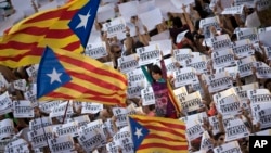 Protesters hold signs reading 'Freedom for the two Jordis' during a march to protest against the National Court's decision to imprison civil society leaders, in Barcelona, Oct. 21, 2017. 