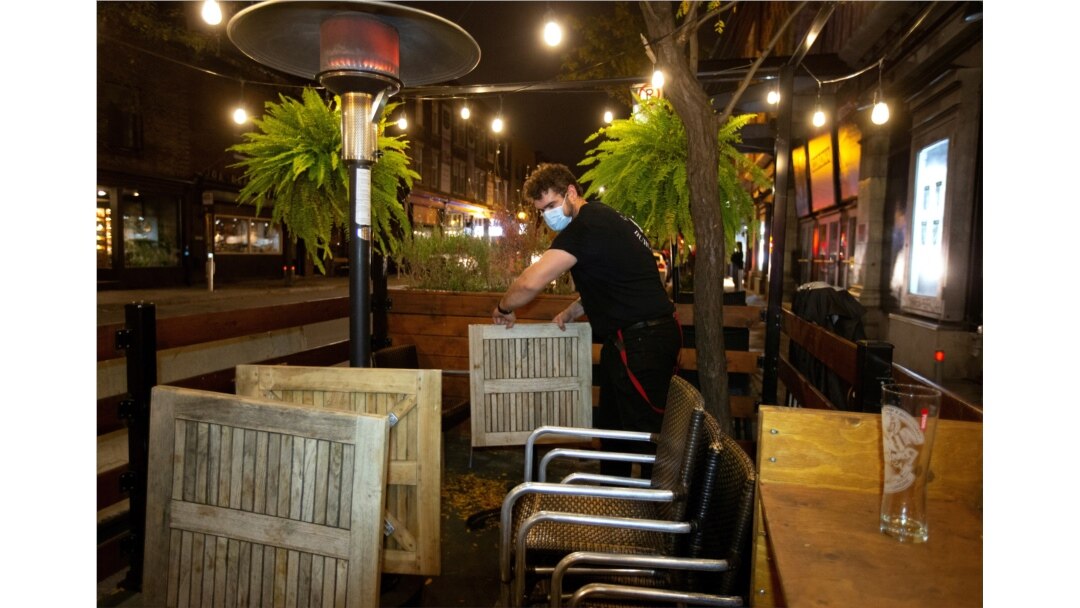Seorang karyawan membongkar teras pemerintah Quebec memerintahkan semua restoran, bar, dan kasino tutup selama 28 hari efektif tengah malam 30 September karena jumlah COVID-19 terus meningkat di Montreal, 30 September 2020. (Foto: Reuters)