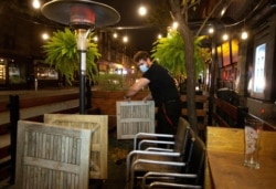 FILE - An employee dismantles the terrasse at closing time after the Quebec government ordered all restaurants, bars and casinos to close for 28 days effective midnight Sept. 30 as COVID-19 numbers continue to rise in Montreal, Sept. 30, 2020.