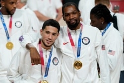 Devin Booker y Kevin Durant posan para una foto durante la ceremonia de entrega de medallas por el juego de baloncesto en los Juegos Olímpicos de Verano de 2020, el sábado 7 de agosto de 2021 en Tokio, Japón. (Foto AP / Charlie Neibergall)