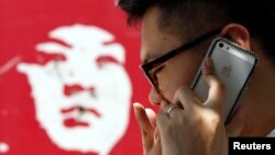 FILE - A man talks on an iPhone in Beijing, July 24, 2013.