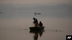 People fish in the waters of the Villa Victoria Dam, the main water supply for Mexico City residents, on the outskirts of Toluca, Mexico, April 22, 2021.