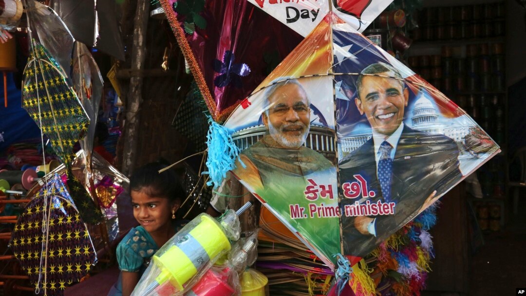 FILE - An Indian girl stands near a kite with portraits of India's Prime Minister Narendra Modi and U.S. President Barack Obama, for sale at a shop ahead of the Hindu festival Makar Sakranti, also known as kite festival, in Hyderabad, India, Jan. 12, 2015.