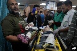 FILE - Palestinian children wounded in the Israeli bombardment of the Gaza Strip are brought to the hospital in Deir al Balah, Gaza Strip, on December 11, 2023.