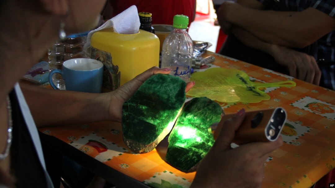 FILE - Local people examine the quality of a jade stone in the Hpakant area of Kachin state, northern Myanmar. 