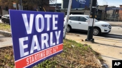 A sign in an Atlanta neighborhood on Dec. 11, 2020, urges people to vote early in Georgia's two U.S. Senate races. 