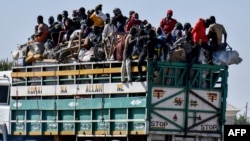 FILE - People who have fled their homes stand on a lorry at an Internally Displaced Persons camp in Maiduguri, Borno state, Nigeria, Nov. 30, 2021.