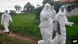 Health workers leave after they took a blood samples from a child to test for the Ebola virus in an area were a 17-year-old boy died from the virus on the outskirts of Monrovia, Liberia, June 30, 2015.