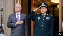 Menteri Pertahanan AS James Mattis (kiri) dan Menhan China Wei Fenghe dalam upacara penyambutan di Pentagon, Jumat (9/11).