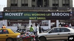 An election poster for Liberian President Ellen Johnson Sirleaf is seen in the heart of the Liberian capital Monrovia. Her slogan "Monkey Still Working Baboon Wait Small" implies she needs a second term to complete her agenda, and currently appears on pos