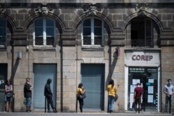 People queue to enter a photocopying shop on May 26, 2020 in Nantes, western France.