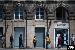 People queue to enter a photocopying shop on May 26, 2020 in Nantes, western France.