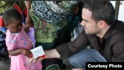 Two Degrees co-founder Will Hauser gives a prepared food packet to a child in Malawi. (Courtesy Two Degrees)