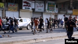 Supporters of Iraqi Shiite armed groups run from security forces after clashes during a protest against the election results in Baghdad, Iraq, Nov. 5, 2021.