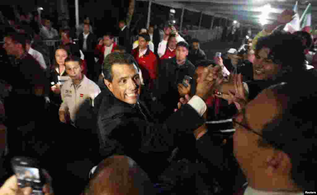 Enrique Pena Nieto greets supporters after exit polls showed him in first place, in Mexico City, July 1, 2012. 