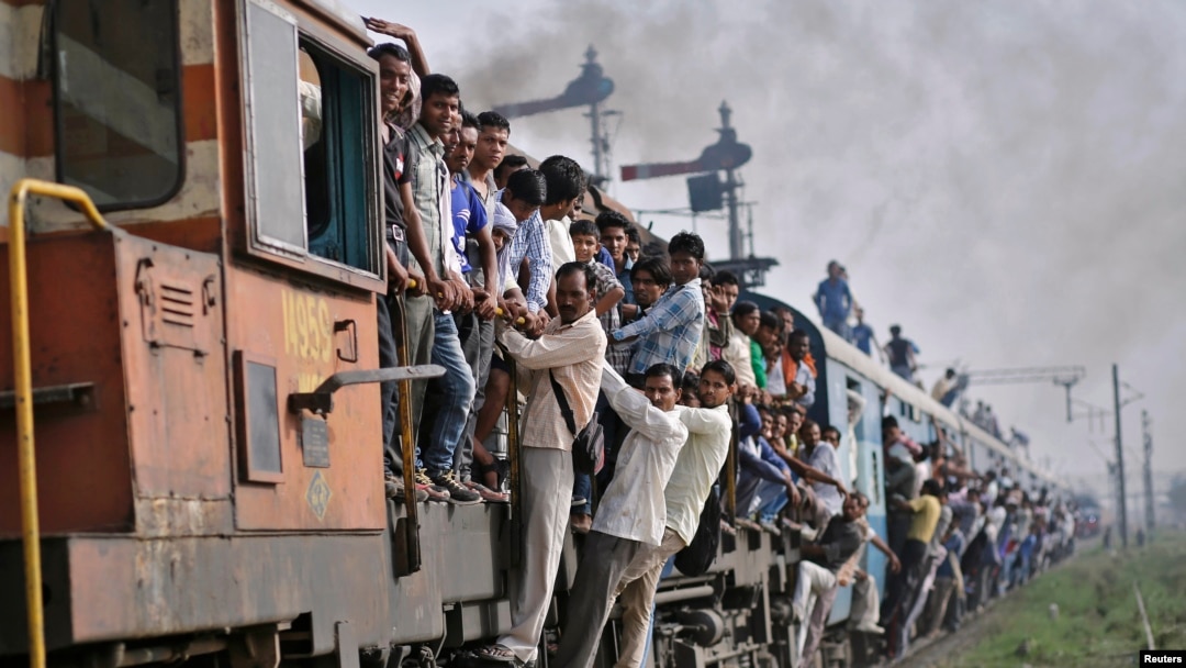 Penumpang bergelantungan di gerbong kereta yang sedang melaju di wilayah Utar Pradesh, India (Foto: dok) Kecelakaan kereta api sering terjadi di India.