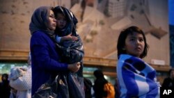 Seorang migran Afghanistan bersama dua anaknya saat tiba di Pulau Lesbos, Yunani (foto: dok). 