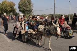 Warga Palestina yang melarikan diri dari Kota Gaza menuju wilayah selatan berjalan dan menaiki kereta yang ditarik keledai di tengah pertempuran Israel -Hamas, 8 November 2023. (Muhammad ABED/AFP)