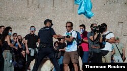 Personas participan en una protesta contra el uso de máscaras protectoras durante la pandemia de la enfermedad por coronavirus (COVID-19), en Madrid, España, 16 de agosto de 2020.