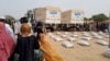 FILE - Sudanese refugees who have fled the violence in their country queue to receive food supplements from World Food Programme (WFP) near the border between Sudan and Chad in Adre, Chad April 26, 2023.