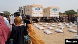 FILE - Sudanese refugees who have fled the violence in their country queue to receive food supplements from World Food Programme (WFP) near the border between Sudan and Chad in Adre, Chad April 26, 2023.