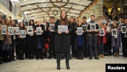 People hold portraits and printed names of victims of the Tu-154 plane, which crashed into the Black Sea on its way to Syria on Sunday, during a memorial event in Rostov-On-Don, Russia, Dec. 26, 2016.