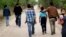 FILE - Migrant families walk from the Rio Grande, the river separating the U.S. and Mexico in Texas, near McAllen, Texas, right before being apprehended by U.S. Border Patrol, March 14, 2019.