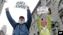 David Pearce, left, and his daughter Crissy Pearce hold signs outside of the 9th U.S. Circuit Court of Appeals in San Francisco, Feb. 7, 2017.