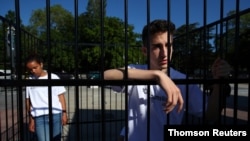 Teenagers are pictured in a cage during a demonstration to condemn the US President Trump administration's policy of child detention in Geneva.