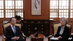 韩国外交部长官康京（右）3月6日召见日本驻韩大使冨田浩司，抗议日本政府针对韩国加强入境管制.