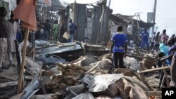 People gather at the scene of a car bomb explosion at the central market, Maiduguri, Nigeria, July 1, 2014.