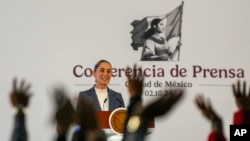 La presidenta mexicana Claudia Sheinbaum ofrece una rueda de prensa mientras los periodistas levantan la mano para hacer preguntas en el Palacio Nacional de la Ciudad de México, el miércoles 2 de octubre de 2024. 