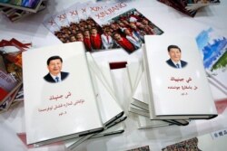 Copies of the book on the governance of Chinese President Xi Jinping are displayed with booklets promoting Xinjiang during a press conference by Shohrat Zakir, chairman of China's Xinjiang Uighur Autonomous Region, July 30, 2019.