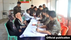 Keluarga pertama pengungsi Rohingya yang pulang tampak bersama anggota militer Myanmar. 