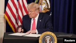 Tổng thống Donald Trump kí các sắc lệnh hành pháp hỗ trợ kinh tế trong một cuộc họp báo tại khu nghỉ dưỡng đánh golf của ông ở Bedminster, New Jersey, ngày 8 tháng 8, 2020. 