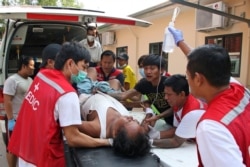 An injured anti-coup protester is brought to a hospital for medical treatment, in Yangon, Myanmar, March 27, 2021.