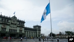 ARCHIVO - Las personas caminan en la Plaza de la Constitución en la Ciudad de Guatemala, en la capital, el martes 4 de septiembre de 2018.