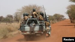 FILE - Burkina Faso soldiers patrol on a road in the Sahel area of Burkina Faso, March 3, 2019.