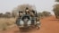FILE - Burkina Faso soldiers patrol on a road in the Sahel area of Burkina Faso, March 3, 2019.