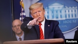 FILE - President Donald Trump takes questions during the coronavirus response daily briefing at the White House in Washington, March 18, 2020. 