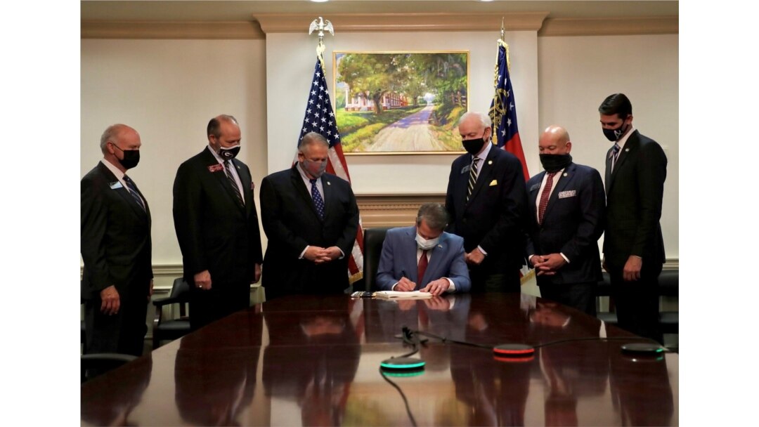 FILE - Georgia Governor Brian Kemp signs a voting law that activists said aims to curtail the influence of Black voters, in this handout photo posted to Kemp's Twitter feed on March 25, 2021.
