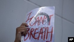 FILE - An activist holds up a picture of Thai dissident Wanchalerm Satsaksit during a rally in front of Cambodian Embassy in Bangkok, Thailand, June 8, 2020. 